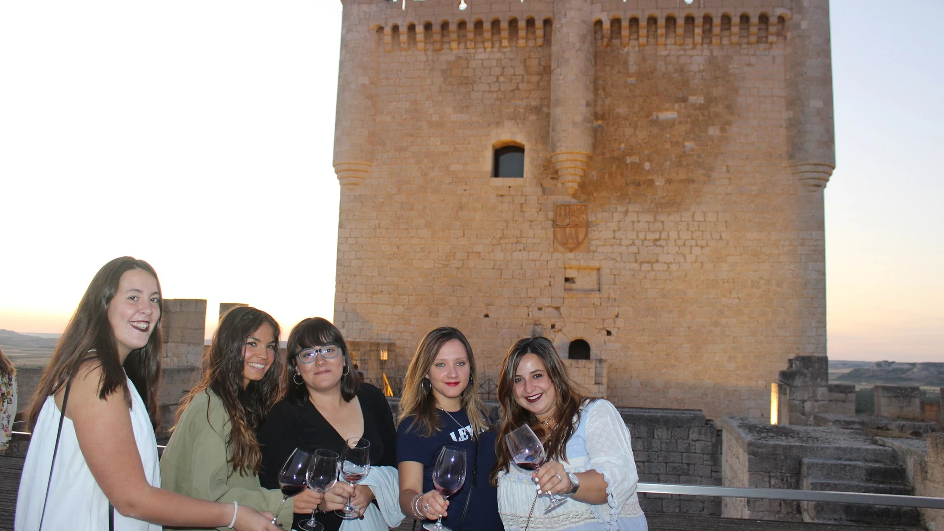 Un grupo de jóvenes brinda con vino de Ribera de Duero en el castillo de Peñafiel (Valladolid)
