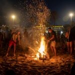 Centenares de personas frente a una hoguera en la playa de la Malvarrosa durante la Noche de San Juan