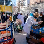 Una voluntaria de una ong entrega alimentos a personas vulnerables