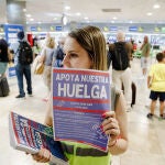 Una trabajadora de Ryanair con carteles durante una concentración en la Terminal 1 del Aeropuerto Adolfo Suárez Madrid Barajas, a 1 de julio de 2022
