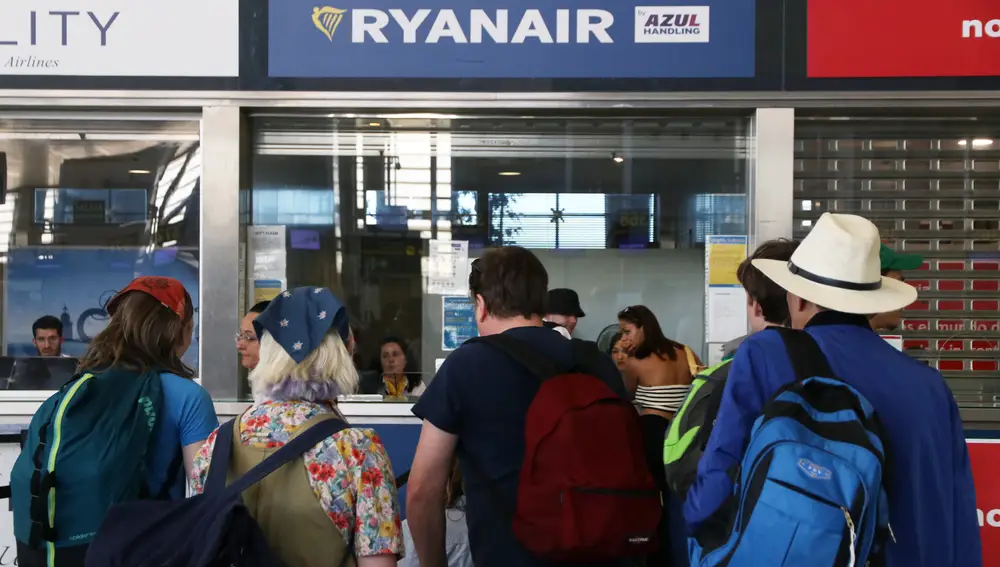 Varias personas se acercan a las ventanillas de Ryanair en el aeropuerto de Málaga, a 1 de julio de 2022