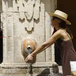 - Una turista se refresca en una de las fuentes de el patio de los naranjos de la Mezquita - Catedral de Córdoba. EFE/Salas