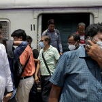 El ministerio de Sanidad de India a alertado hoy del llamativo incremento de casos de covid en el país. En la imagen, pasajeros con y sin mascarilla en una estación de tren de Calcuta.