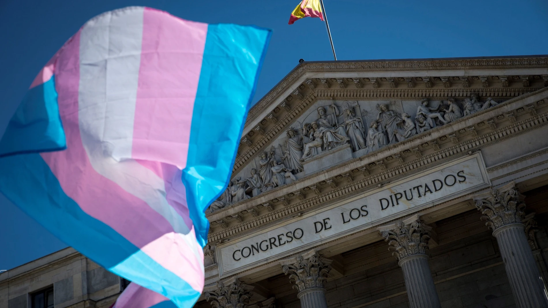 Una bandera del colectivo transexual ondea a las puertas del Congreso, en Madrid