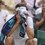 Taylor Fritz se cubre el rostro durante su partico contra Rafa Nadal en Wimbledon.