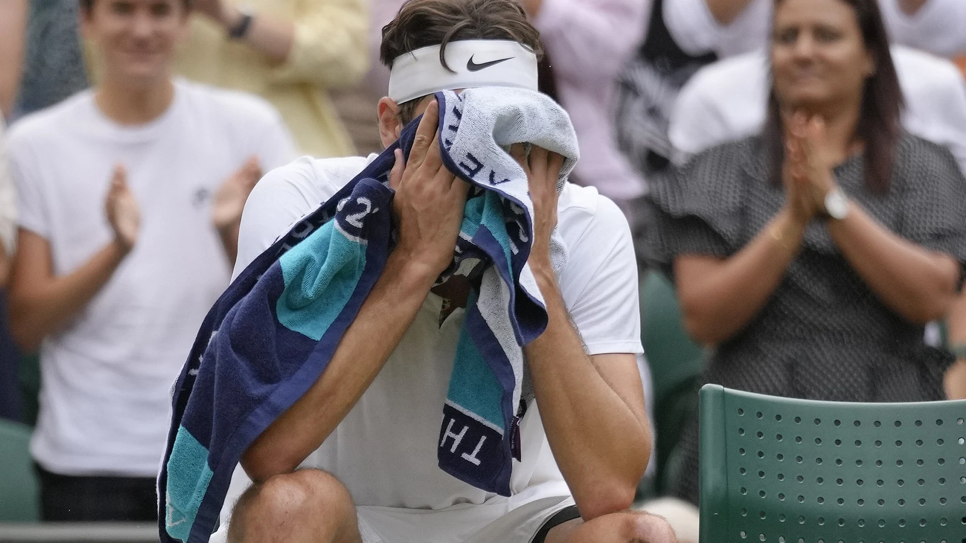 Taylor Fritz se cubre el rostro durante su partico contra Rafa Nadal en Wimbledon.