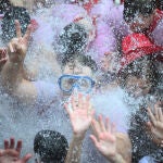 Un grupo de jóvenes se moja con agua tras el chupinazo en la Plaza Consistorial de Pamplona e