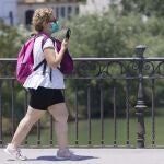 Una mujer con mascarilla cruza el puente de Triana, en Sevilla