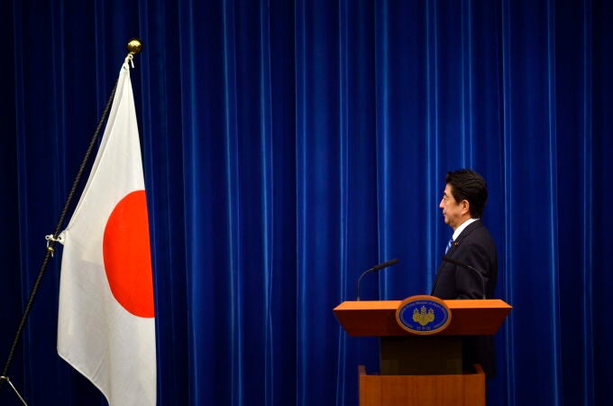 Shinzo Abe posa frente a la bandera nacional en la residencia del primer ministro en Tokio en 2013