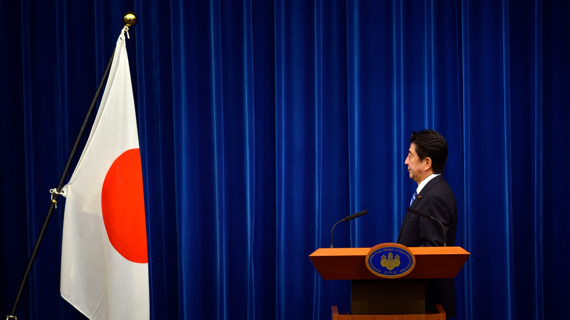 Shinzo Abe posa frente a la bandera nacional en la residencia del primer ministro en Tokio en 2013