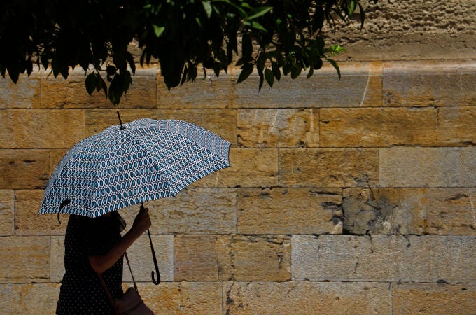 Una persona se protege con un paraguas de las altas temperaturas en Córdoba. EFE/Salas