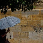 Una persona se protege con un paraguas de las altas temperaturas en Córdoba. EFE/Salas