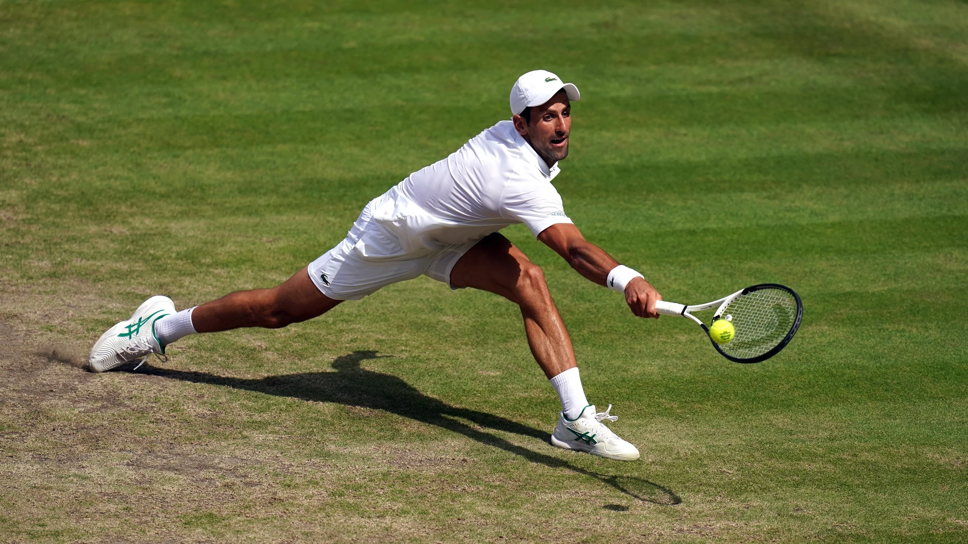 Novak Djokovic se estira para llegar a una bola en la final de Wimbledon 2022 contra Kyrgios