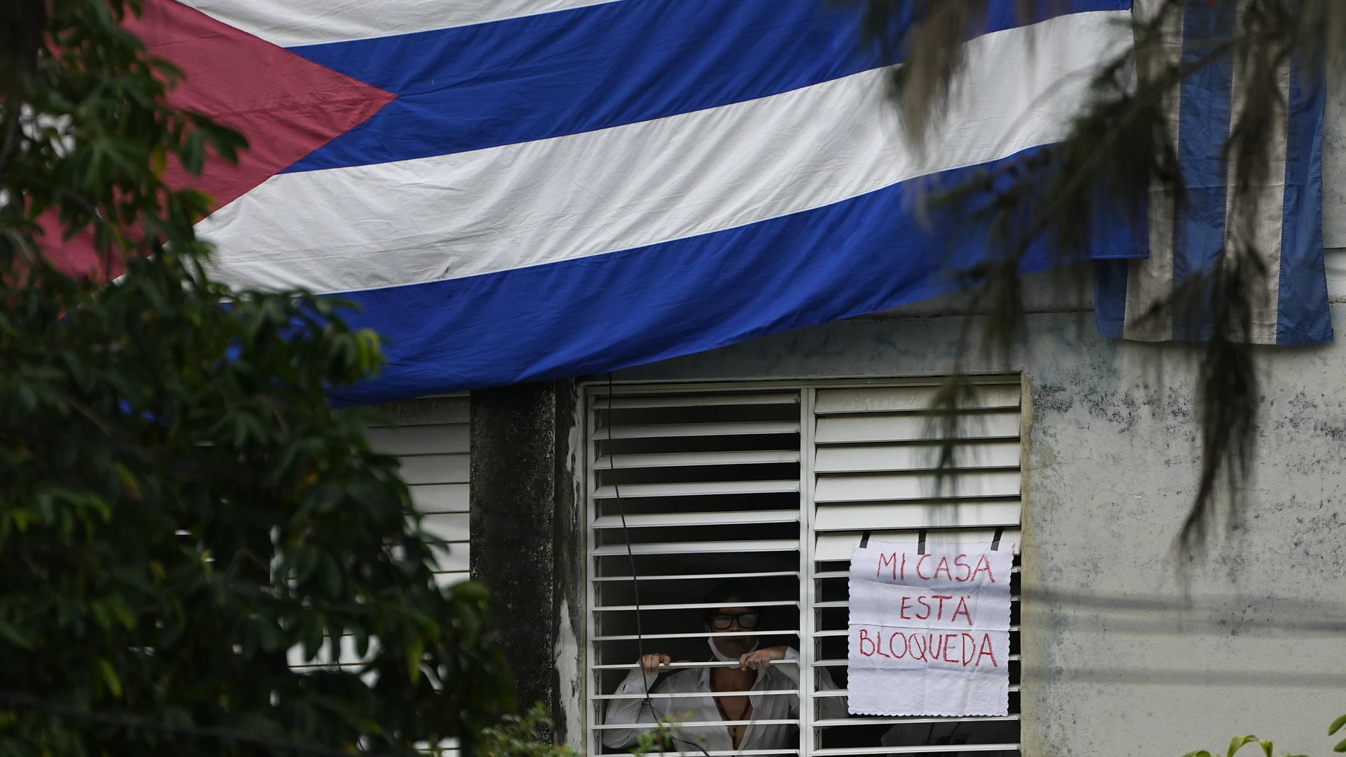 ARCHIVO - Yunior García, dramaturgo y uno de los organizadores de una marcha de protesta, de pie junto a un cartel que dice en español "mi casa está bloqueada", que colocó en una ventana de su casa, en La Habana, Cuba, el domingo. 14 de noviembre de 2021. 
 (AP Photo/Ramon Epinosa, Expediente)