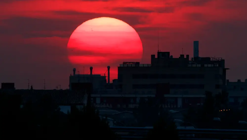 El sol se oculta tras un edificio a las afueras de Zaragoza | Fuente: EFE/Javier Cebollada