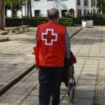 Un voluntario de la Cruz Roja acompaña a una persona mayor