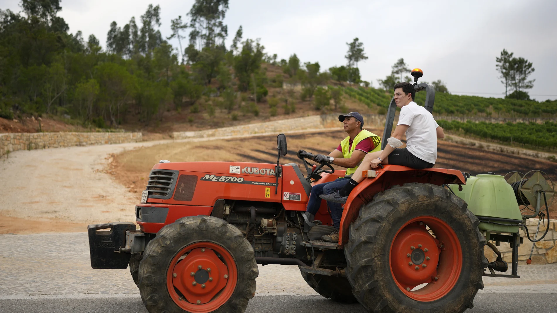 Dos hombres montados en un tractor (AP Photo/Armando Franca)