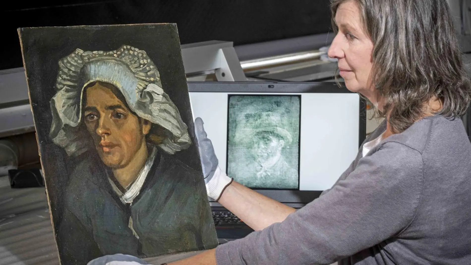 La conservadora Lesley Stevenson, sosteniendo la obra de la campesina que ocultaba el autorretrato de Van Gogh