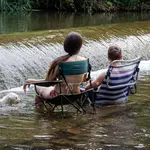 Unos jóvenes se refrescan en el río Iregua a su paso por Logroño el pasado mes de julio