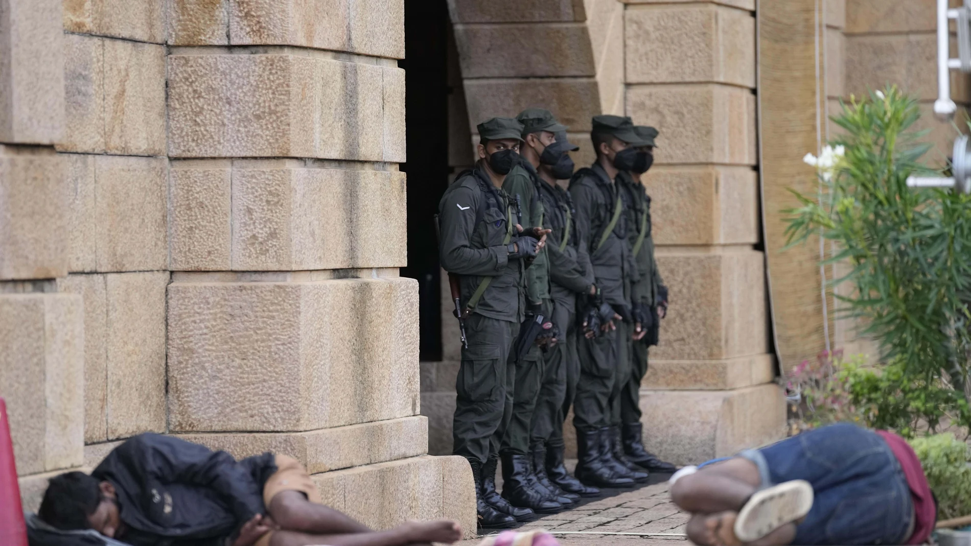 Soldados del ejército hacen guardia mientras los manifestantes duermen junto a la entrada de la oficina del presidente en Colombo, Sri Lanka