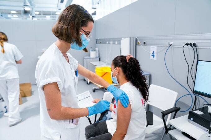 Una enfermera vacuna a una mujer en el Hospital público de emergencias Enfermera Isabel Zendal, a 28 de junio de 2021, en Madrid, (España). A partir de hoy este hospital va a comenzar a vacunar contra el Covid-19, 24 horas al día, a través del sistema de autocitación. En el recinto se pondrán en torno a 150.000 vacunas a la semana de manera ininterrumpida. 28 JUNIO 2021;MADRID;ZENDAL;VACUNA;COVID-19;PANDEMIA;AUTOCITACIÓN A. Pérez Meca / Europa Press 28/06/2021
