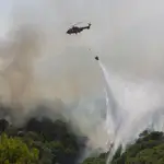 Un helicóptero del servicio de bomberos trabaja en un incendio declarado en la sierra de Mija