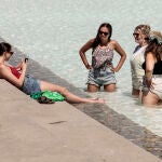 Unas jóvenes se refrescan en una fuente este lunes en la ciudad de Valencia