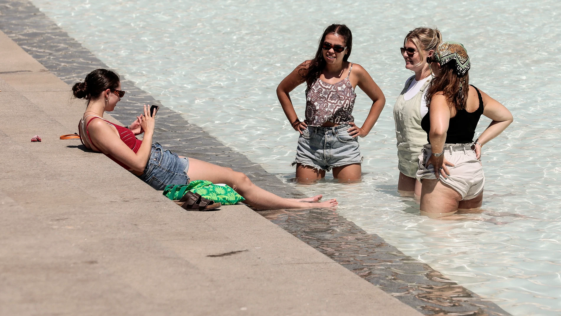 Unas jóvenes se refrescan en una fuente este lunes en la ciudad de Valencia