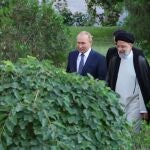 Imagen ofrecida por el Gobierno iraní en la que se observa al presidente Ebrahim Rais con su homólogo ruso caminando en el jardín en Teherán