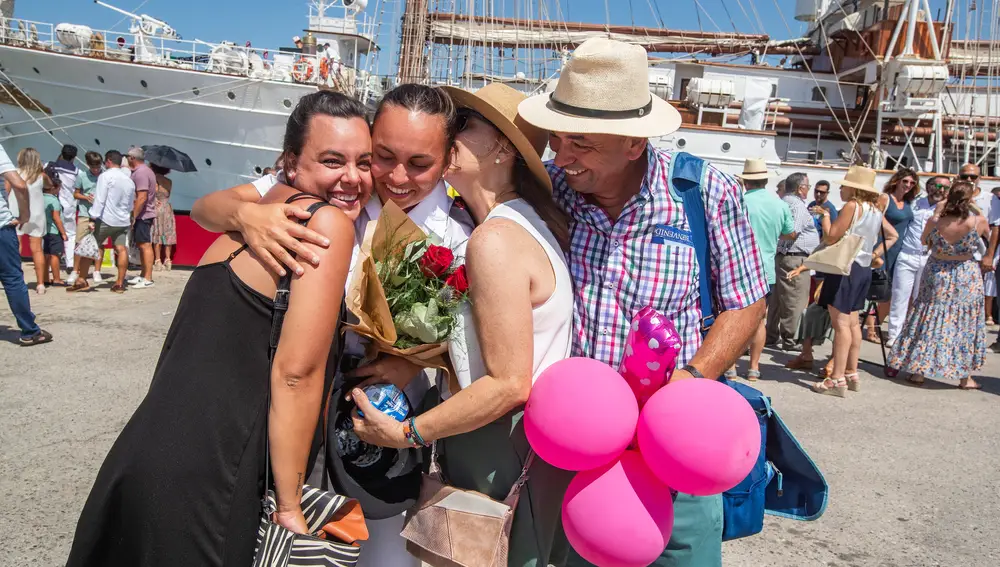 Familiares y amigos abrazan a una joven que forma parte de los 227 futuros oficiales de la Armada española saludan a su regreso a bordo del buque escuela Juan Sebastián Elcano. EFE/Román Ríos.