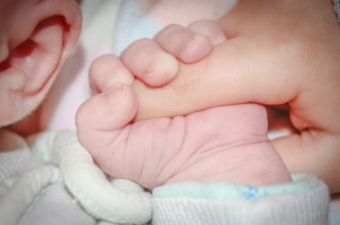 Fotografía de la mano de un bebé agarrando un dedo