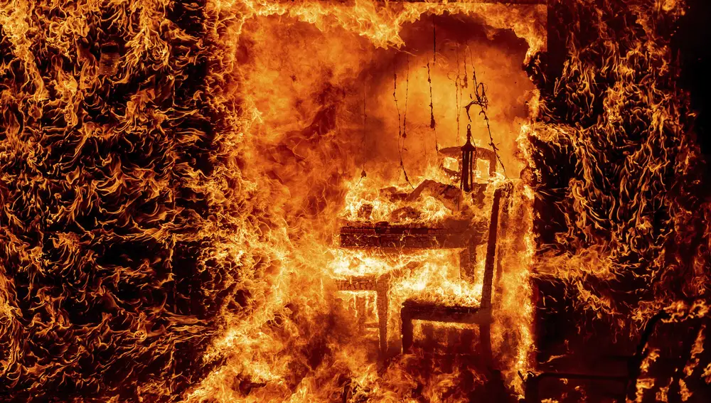 Las llamas envuelven una silla dentro de una casa en llamas mientras arde el incendio de Oak en el condado de Mariposa