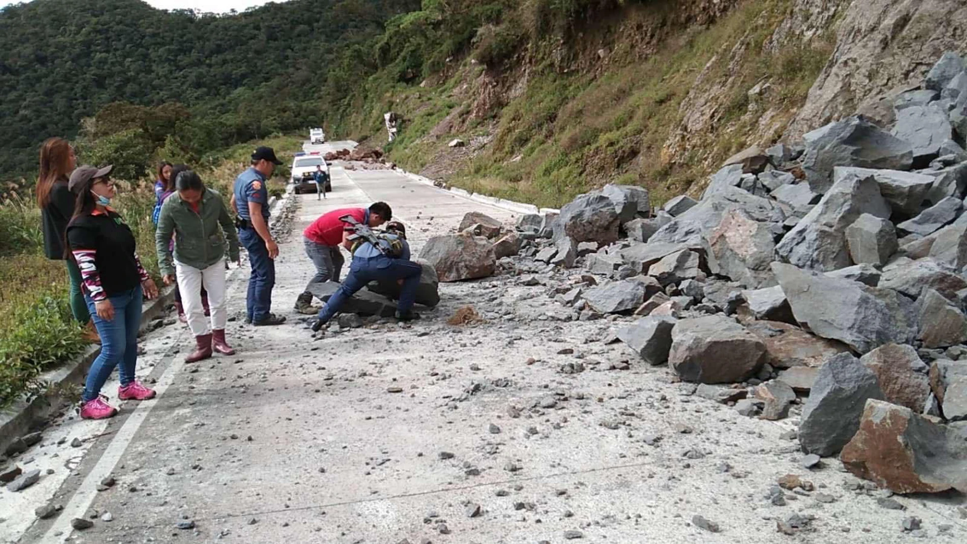 Vecinos de una aldea despejan piedras de una carretera tras un terremoto en Tinok hi-way, región de la Cordillera, en Filipinas
