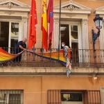 Operarios municipales retiran la bandera del edificio de grupos