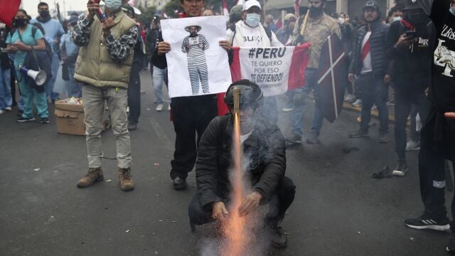 Manifestantes queman una foto del presidente Pedro Catillo cerca del Congreso en Lima