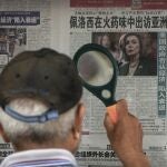 Un hombre lee con una lupa en Pekín una noticia sobre Nancy Pelosi