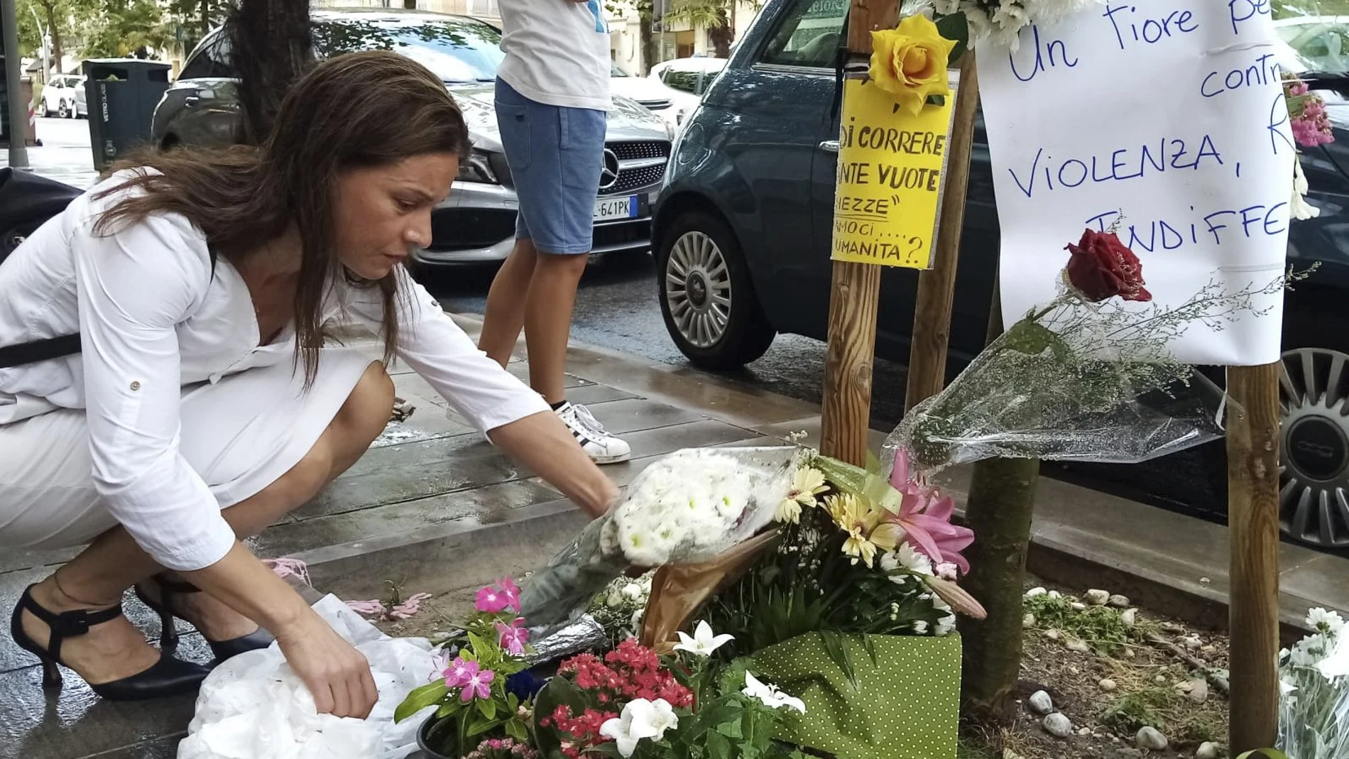 Una mujer deposita un ramo de flores en lugar donde fue asesinado Alika Ogorchukwu en Civitanova