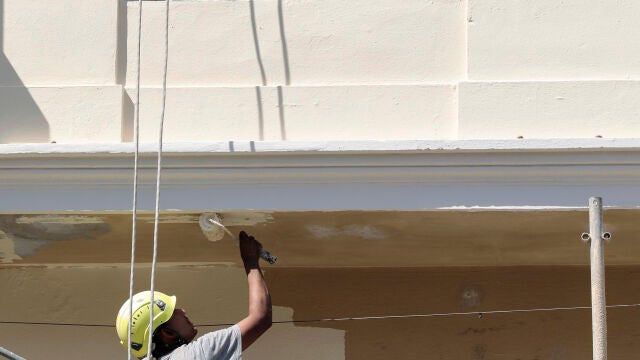 Dos albañiles trabajan en la restauración de la fachada. EFE/Ana Escobar