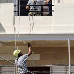 Dos albañiles trabajan en la restauración de la fachada. EFE/Ana Escobar