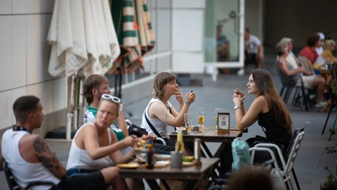 Varias personas sentadas en terrazas en la plaza dels Àngels del Raval