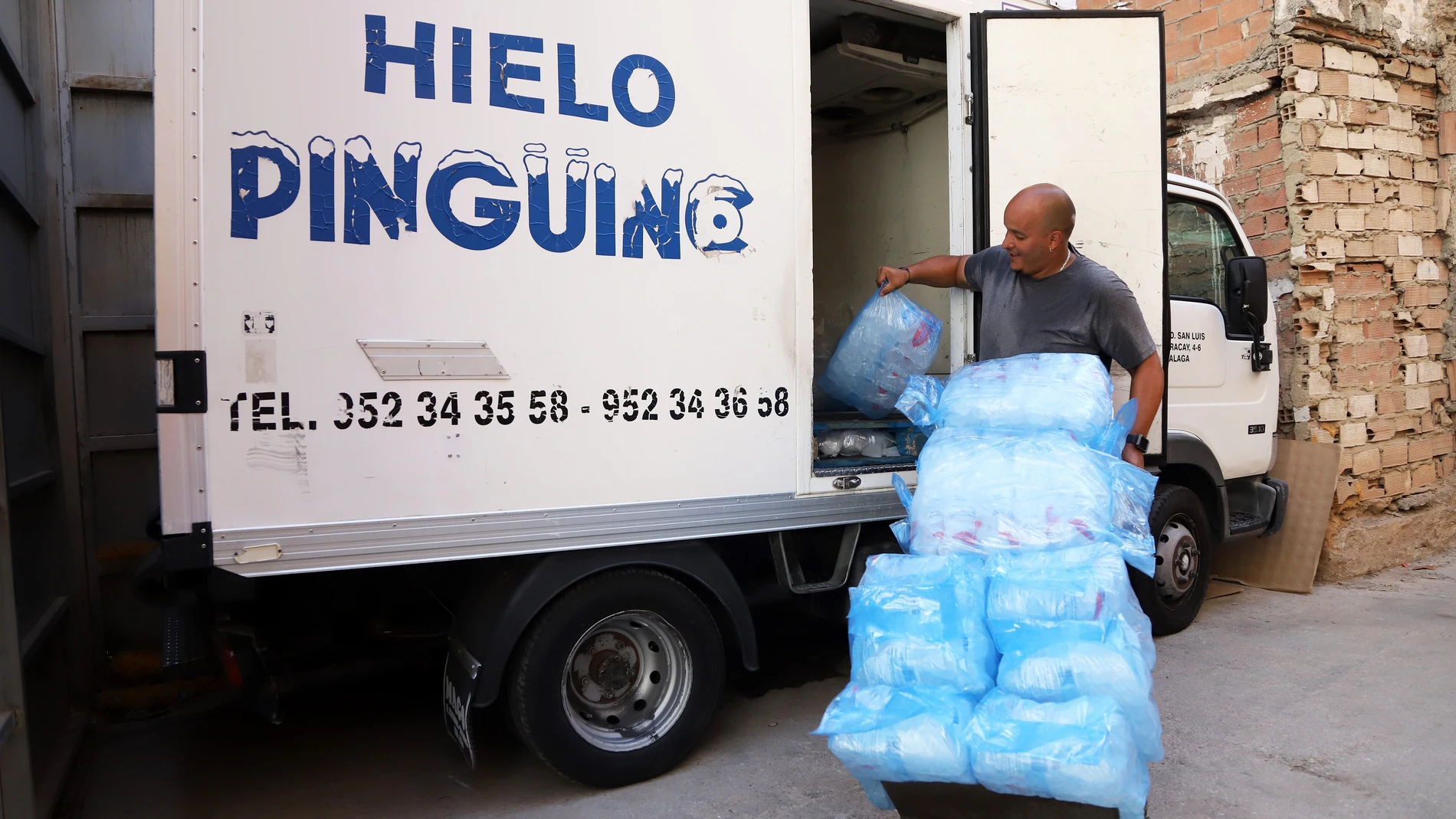 Un repartidor de hielo distribuye a sus clientes