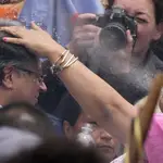 Una mujer indígena escupe agua sobre la cabeza del presidente electo Gustavo Petro, durante una ceremonia de investidura &quot;popular y espiritual&quot; presidida por grupos indígenas locales y activistas feministas, en Bogotá