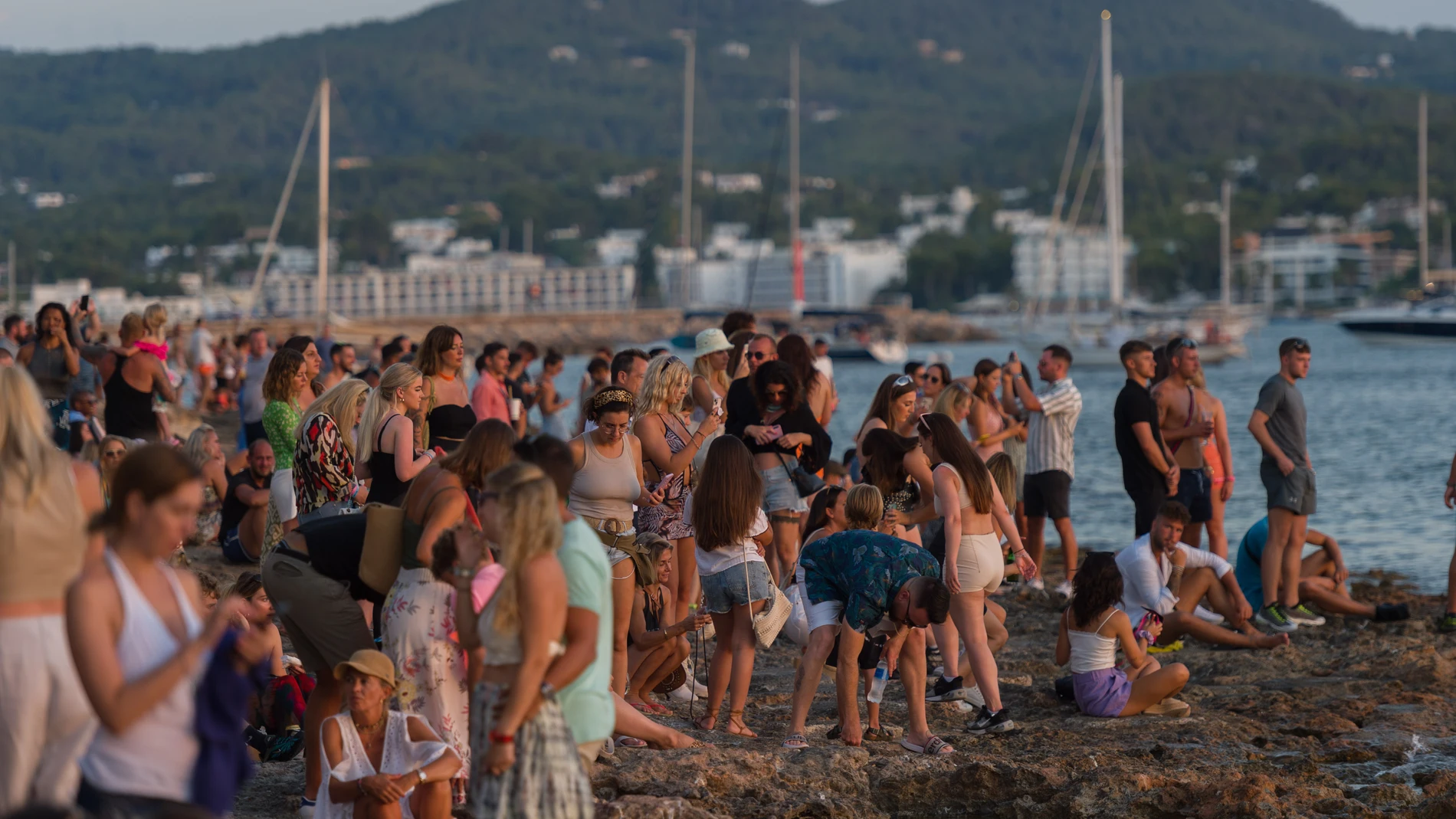 Varias personas contemplan la puesta de sol en la isla de Ibiza