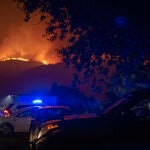 Un agente de la Guardia Civil en el interior de su vehículo en el incendio forestal cercano a la localidad de Bustelo (Pontevedra), que tuvo que ser desalojada por la cercanía de las llamas