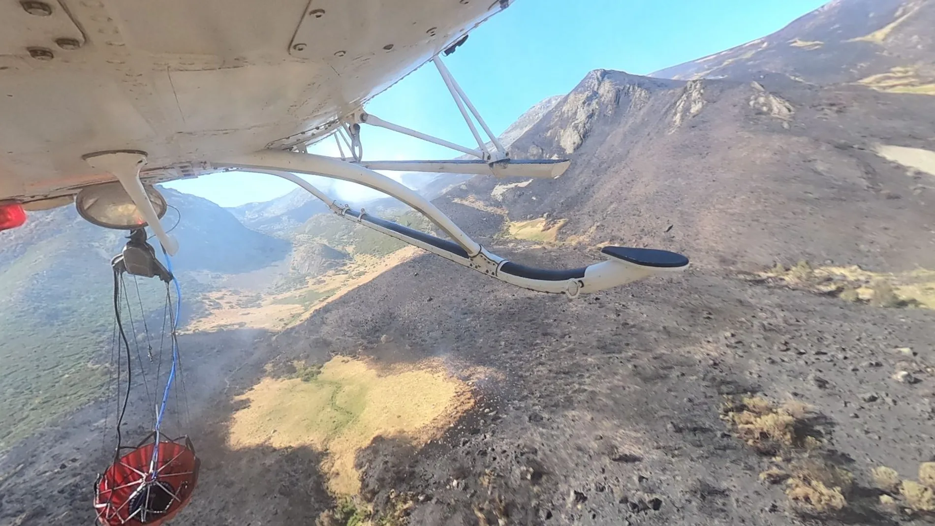 Un helicóptero descarga agua en el incendio de Boca de Huérgano, en León