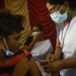 Un sanitario vacunando a un hombre frente a la covid en Chennai, India, a 12 de agosto de 2022