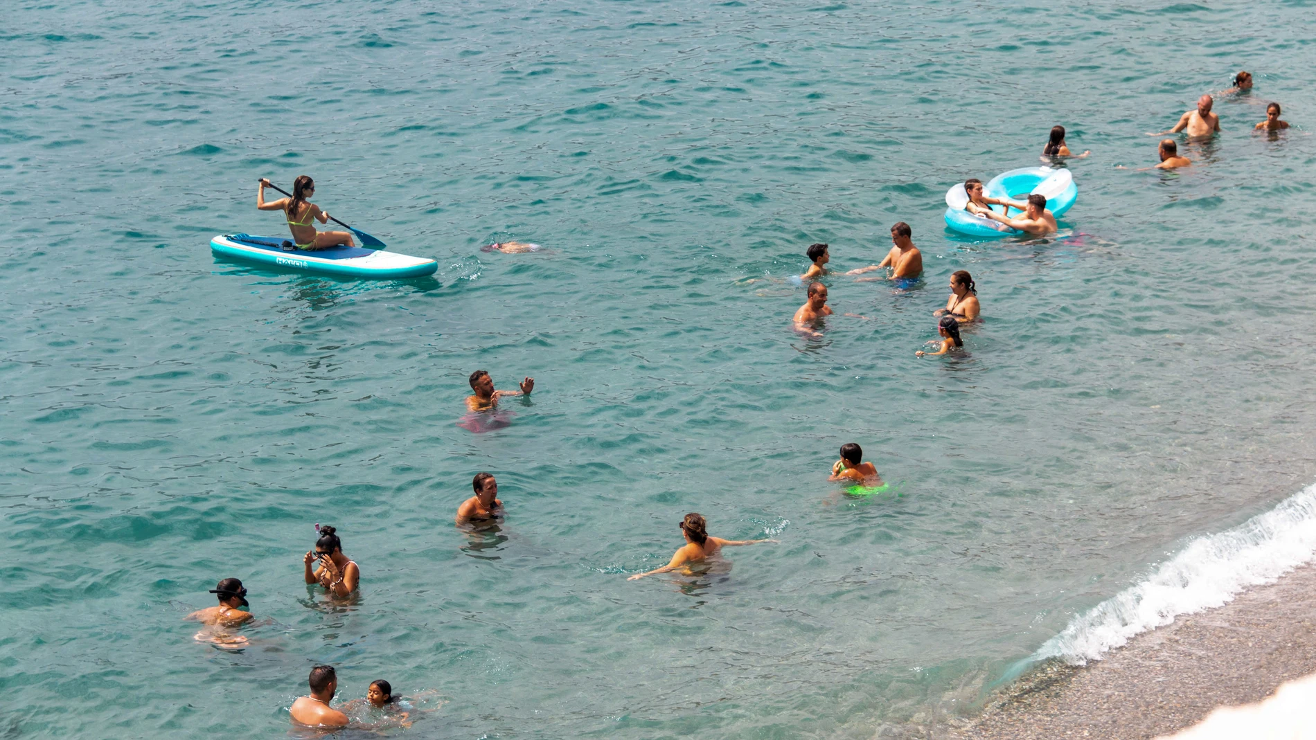 Varias personas refrescándose en la playa de La Herradura en la localidad granadina de Almuñécar. EFE/ Alba Feixas