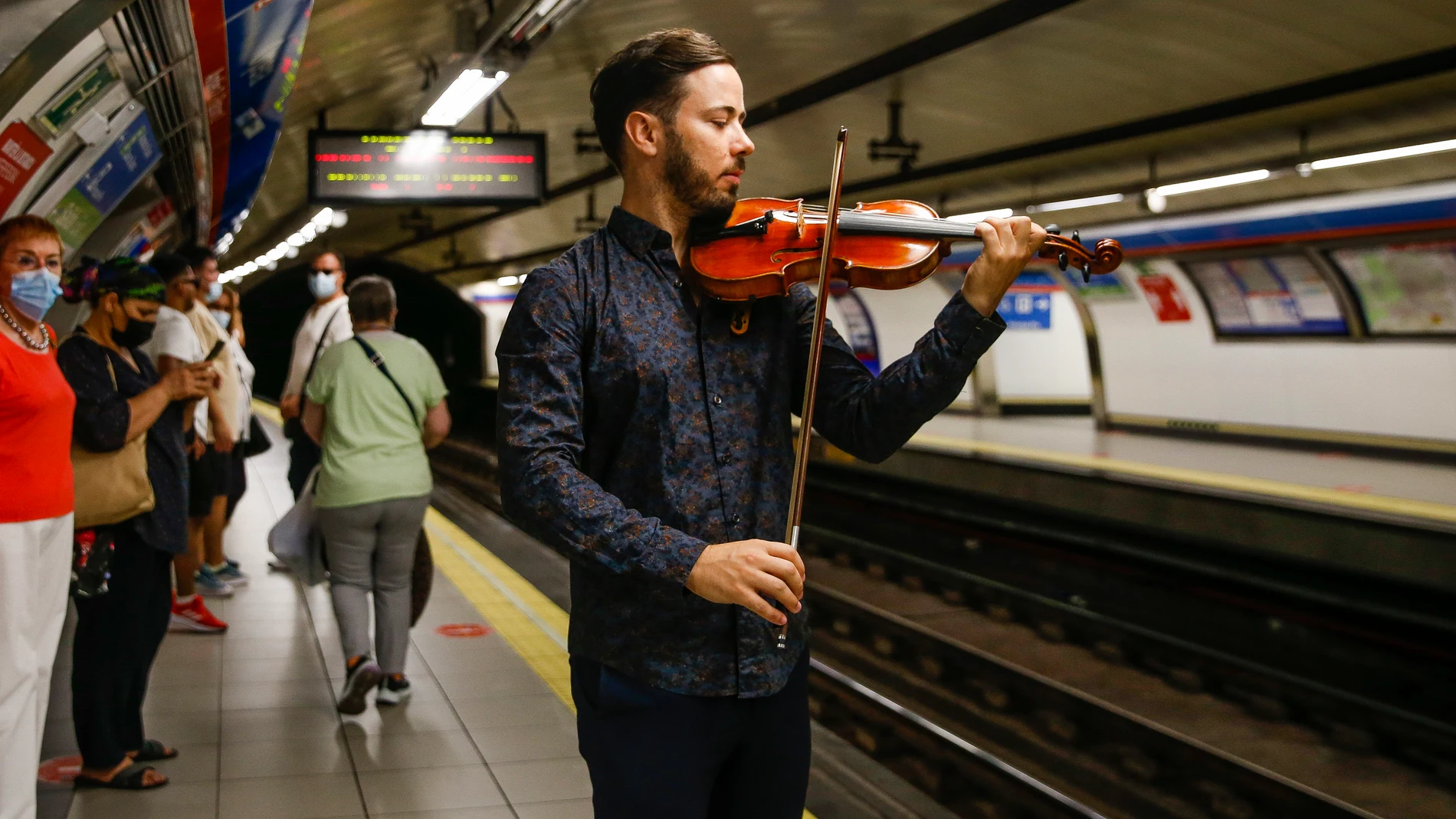 Un violinista en el andén de la estación de Ópera durante la presentación de un proyecto piloto para reproducir piezas de música clásica por la megafonía de las estaciones de la red de Metro