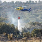 Un helicóptero realiza labores de extinción este sábado, tras el incendio originado en Bejís