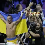 Usyk celebra su victoria envuelto en la bandera de su país.